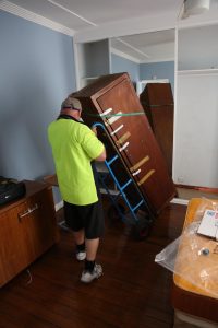 man delivering a dresser on a cart